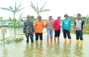 Jalan Tergenang Air, Babinsa Koramil Turi Lamongan Bergerak Cepat Pasang Pembatas